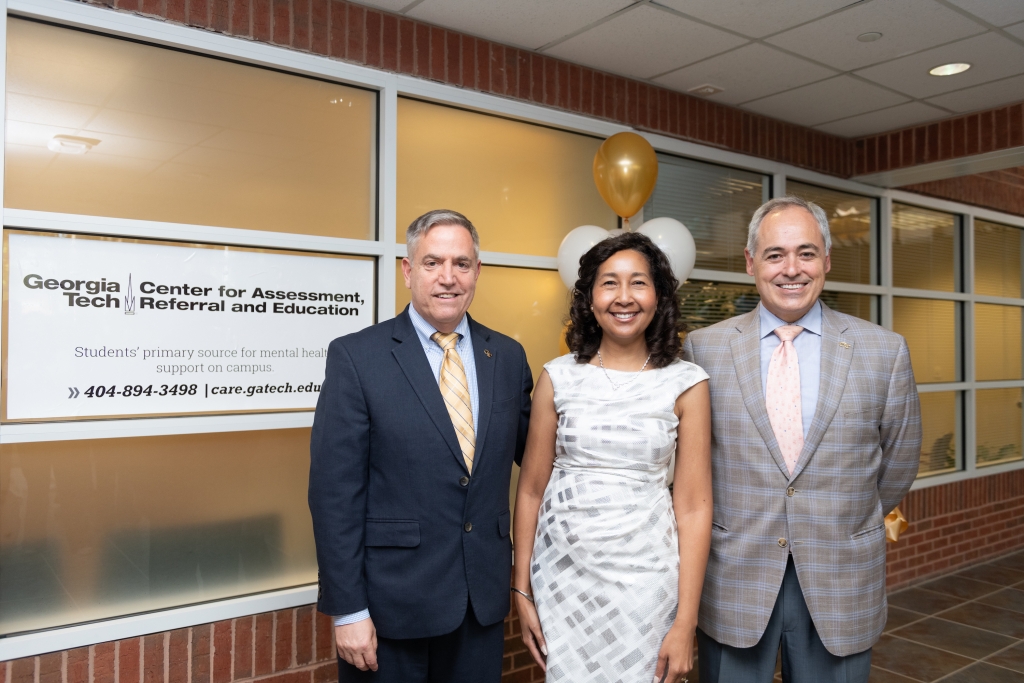 adults standing outside of an office